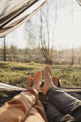 Couple relaxing in tent on sunny day - ANAF01370