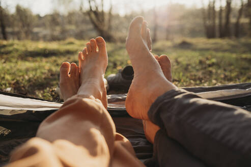 Couple spending leisure time in tent on sunny day - ANAF01371