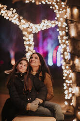Mutter und Tochter betrachten die Weihnachtsbeleuchtung - GMLF01466