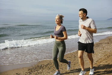 Älteres Paar joggt zusammen an einem sonnigen Tag - EBSF03257