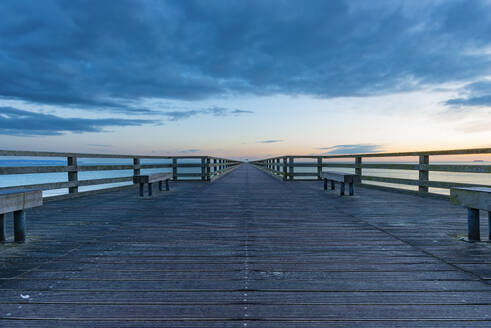 Germany, Mecklenburg-Vorpommern, Binz, Clouds over Seebrucke Binz pier at dusk - WGF01464