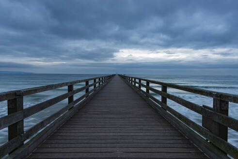 Germany, Mecklenburg-Vorpommern, Binz, Clouds over Seebrucke Binz pier at dusk - WGF01465