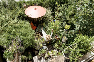 Man with arms raised relaxing in garden - HHF05887