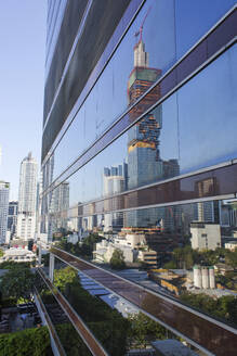 Thailand, Bangkok, Skyscrapers reflecting in glass wall - IKF00404