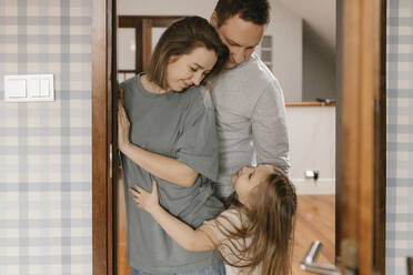 Tochter umarmt Eltern an der Tür zu Hause - VIVF00783
