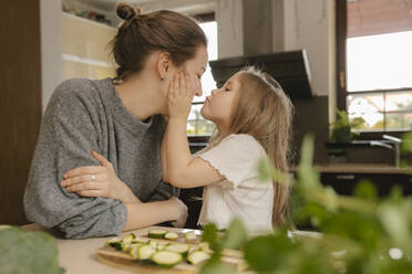 Tochter küsst Mutter in der Küche - VIVF00812