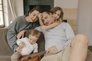 Family spending leisure time with ukulele in living room - VIVF00829