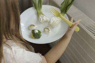 Girl holding vegetables on plate - VIVF00842