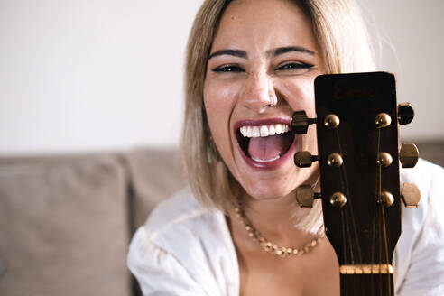 Fröhlicher blonder Musiker mit Gitarre - AMWF01300