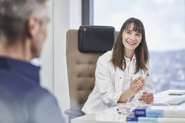 Smiling female doctor talking to senior patient in medical practice - RORF03476