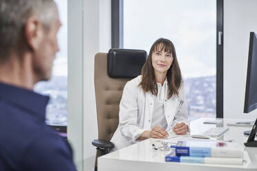 Female doctor looking at senior patient in medical practice - RORF03477