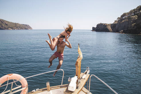 Man and woman jumping in sea from boat at vacation - PCLF00464