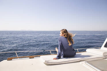 Frau sitzt auf dem Bootsdeck an einem sonnigen Tag - PCLF00467