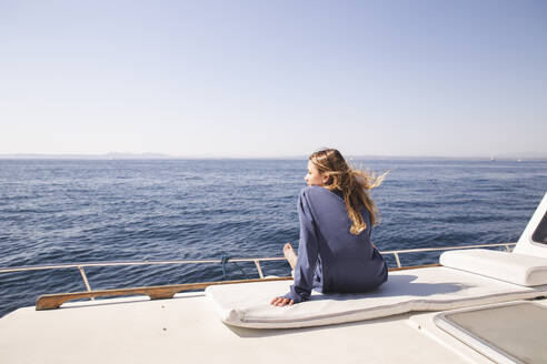 Woman sitting on boat deck at sunny day - PCLF00467