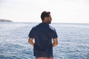 Rear view of man looking at sea - PCLF00470