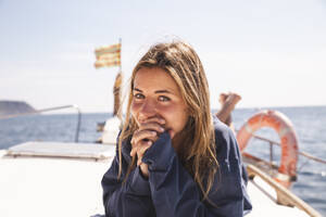 Young woman with hands clasped lying on yacht at sunny day - PCLF00475