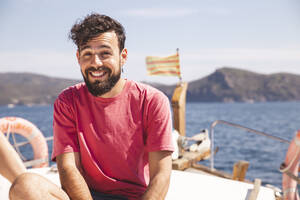 Smiling man enjoying vacation on yacht at sunny day - PCLF00477