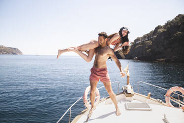 Mann ohne Hemd hat Spaß mit Freundin auf Jacht im Urlaub - PCLF00496