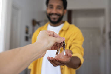 Hand eines Immobilienmaklers, der einem Mann die Hausschlüssel gibt - VRAF00116