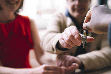 Real estate agent giving house keys to couple - AMWF01319