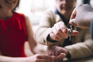 Immobilienmakler übergibt Hausschlüssel an Paar - AMWF01319