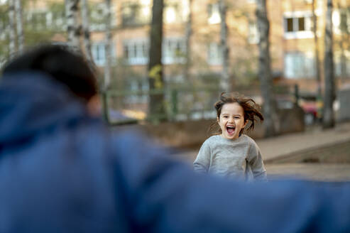 Excited son running towards father at park - ANAF01384