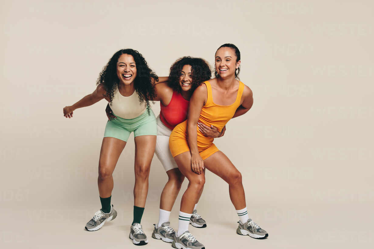 Group of young female athletes laughing and having fun in fitness clothing,  celebrating their love for sport and exercise. Happy young sportswomen  demonstrating their commitment to a healthy lifestyle. stock photo