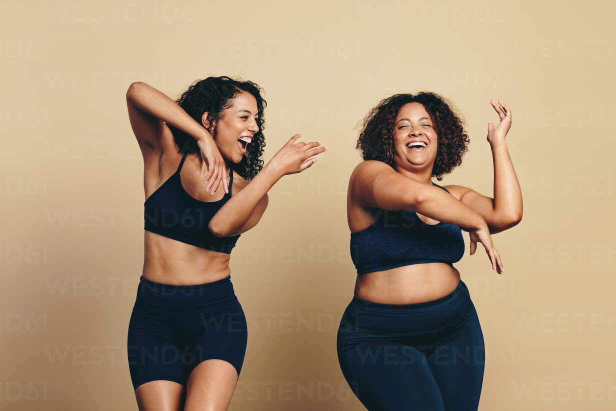 Athletic plus size woman dancing in a studio, expressing body