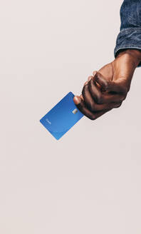 Ein schwarzer Mann geht mit seiner Kreditkarte einkaufen, die eine bequeme Methode für bargeldlose Zahlungen darstellt. Electronic Banking ist zum bevorzugten Lebensstil junger Menschen geworden. - JLPPF01637