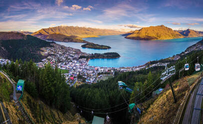 Picturesque view of blue lake surrounded by mountains near green coniferous trees in Queenstown with cable transport - ADSF43843