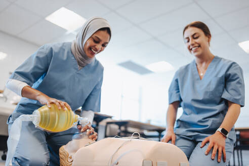 Studentin mit Hidschab übt während einer klinischen Simulation die Wiederbelebung an einer medizinischen Puppe. Junge Frauen lernen während ihrer medizinischen Ausbildung in einem Lehrkrankenhaus, wie man einen Patienten wiederbelebt. - JLPPF01786