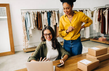 Female dropshippers having a video call on a laptop, communicating with their suppliers for the online clothing store. Successful women using their entrepreneurial abilities to grow their small business. - JLPSF30200