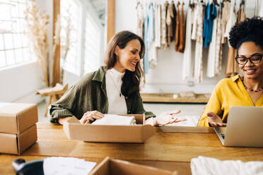 Zwei Geschäftsfrauen, die eine E-Commerce-Website betreiben und ihre Einzelhandelspräsenz durch einen Online-Shop für ihre Bekleidungsprodukte erweitern. - JLPSF30210