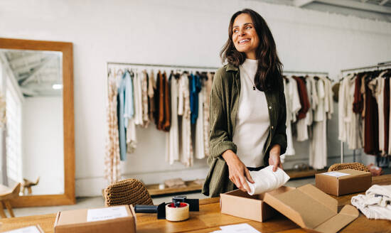 With a strong entrepreneurial spirit, this businesswoman prepares a dropshipping order in her clothing boutique, driven to succeed in the world of ecommerce and make her online store a success. - JLPSF30227