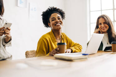 Eine Gruppe talentierter weiblicher Fachleute trifft sich, um innovative Ideen und Strategien für den Erfolg ihres Start-ups zu besprechen. Glückliche Geschäftsfrauen arbeiten zusammen in einem Büro. - JLPSF30261