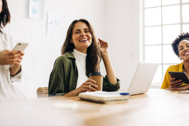 Team of professional and determined business women having a meeting together, happily participating in the discussion and contributing their ideas for the growth of the all female company. - JLPSF30262