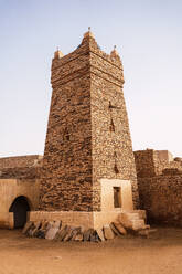 Old stone Chinguetti Mosque against cloudless blue sky located in ancient city of Mauritania - ADSF44006