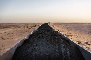 Mauretanischer Eisenerzzug fährt durch trockene Wüstenlandschaft gegen den Himmel in der Sahara Afrikas - ADSF44007