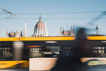 Unscharfe Bewegung von schnell fahrenden elektrischen Zug in belebten Straße von mittelalterlichen Kathedrale in Budapest Ungarn - ADSF44023