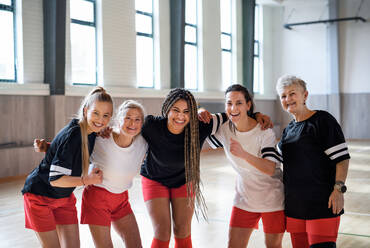 Eine Gruppe junger und älterer Frauen in einer Turnhalle, die in die Kamera schauen, Sportmannschaftsspieler. - HPIF09333