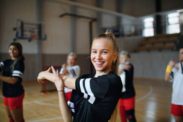 Eine Gruppe von Mehrgenerationen-Frauen, die in einer Sportmannschaft spielen, dehnt sich und wärmt sich vor einem Spiel auf. - HPIF09367