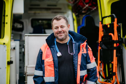 Portrait of rescuer standing in front of ambulance car. - HPIF09422