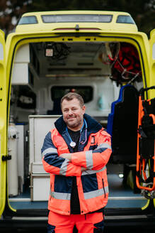 Portrait of rescuer standing in front of ambulance car. - HPIF09423