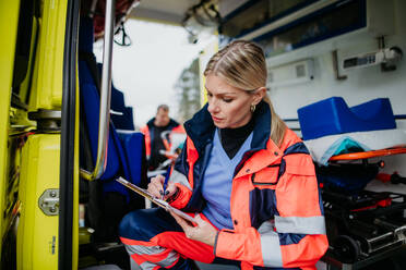 Young rescuer doctor checking equipment in an ambulance car. - HPIF09430