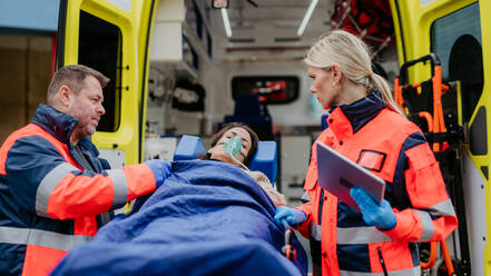 Rettungskräfte versorgen eine Patientin und bereiten sie für den Transport vor. - HPIF09451
