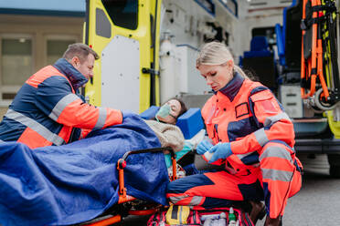 Rettungskräfte versorgen eine Patientin und bereiten sie für den Transport vor. - HPIF09454