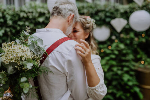 Nahaufnahme von Braut und Bräutigam beim Tanzen auf ihrer Hochzeit im Freien. - HPIF09483