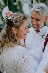 Nahaufnahme von Braut und Bräutigam beim Tanzen auf ihrer Hochzeit im Freien. - HPIF09498