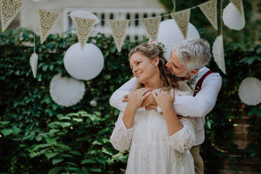 Nahaufnahme von Braut und Bräutigam beim Tanzen auf ihrer Hochzeit im Freien. - HPIF09510