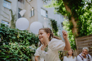 Kleines Mädchen hat Spaß auf einer Hochzeitsfeier im Freien. - HPIF09515